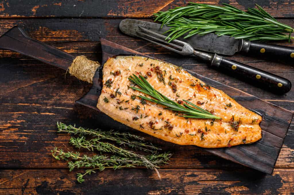 pan seared rainbow trout dish on cutting board with herbs pan seared rainbow trout dish on cutting board with herbs