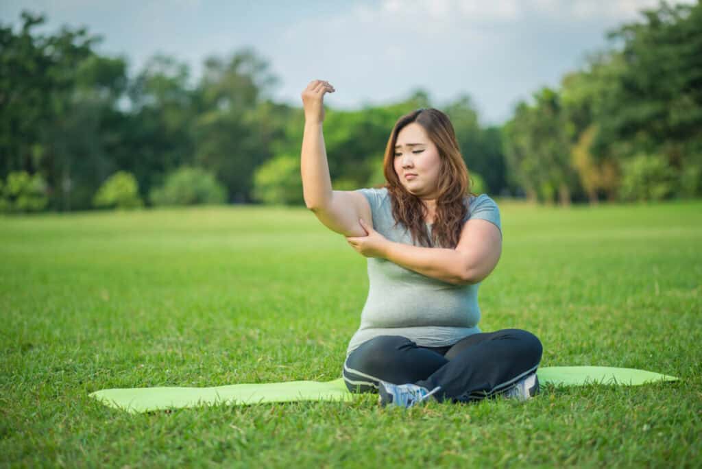 fatty woman checking her fat arm in the garden
Exercises To Get Rid of Upper Arm Fat 