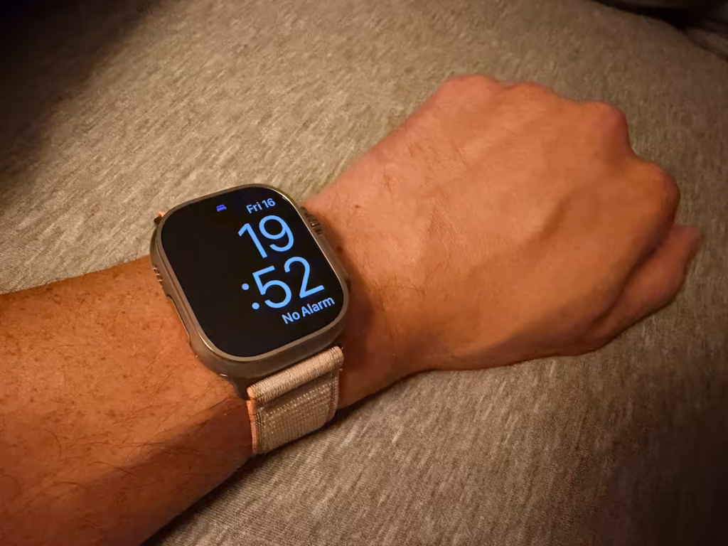 apple watch ultra 4 sleep tracking wrist setup Apple Watch Ultra 4 with a fabric band on my wrist resting on bedding, displaying the time and Sleep Focus icon.